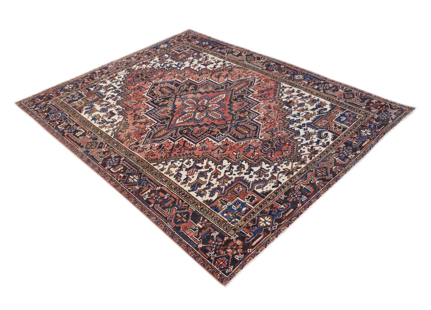 A vintage handwoven Persian Heriz rug featuring a geometric medallion on a terracotta field.