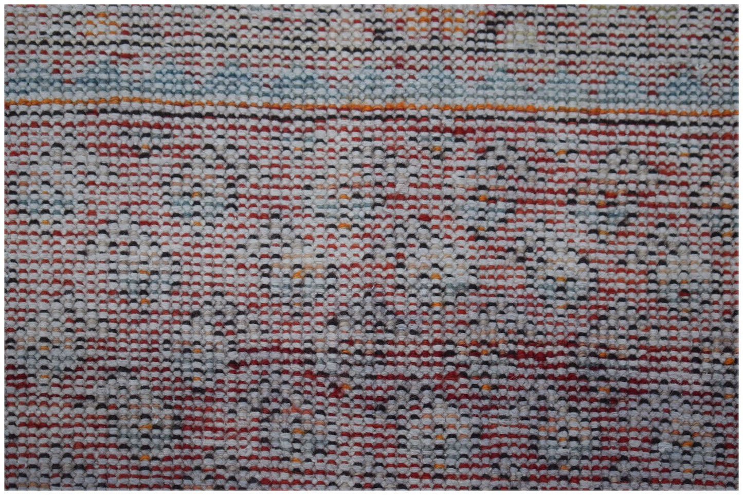 A vintage handwoven Persian rug featuring a repeating geometric pattern in red, white, and blue.