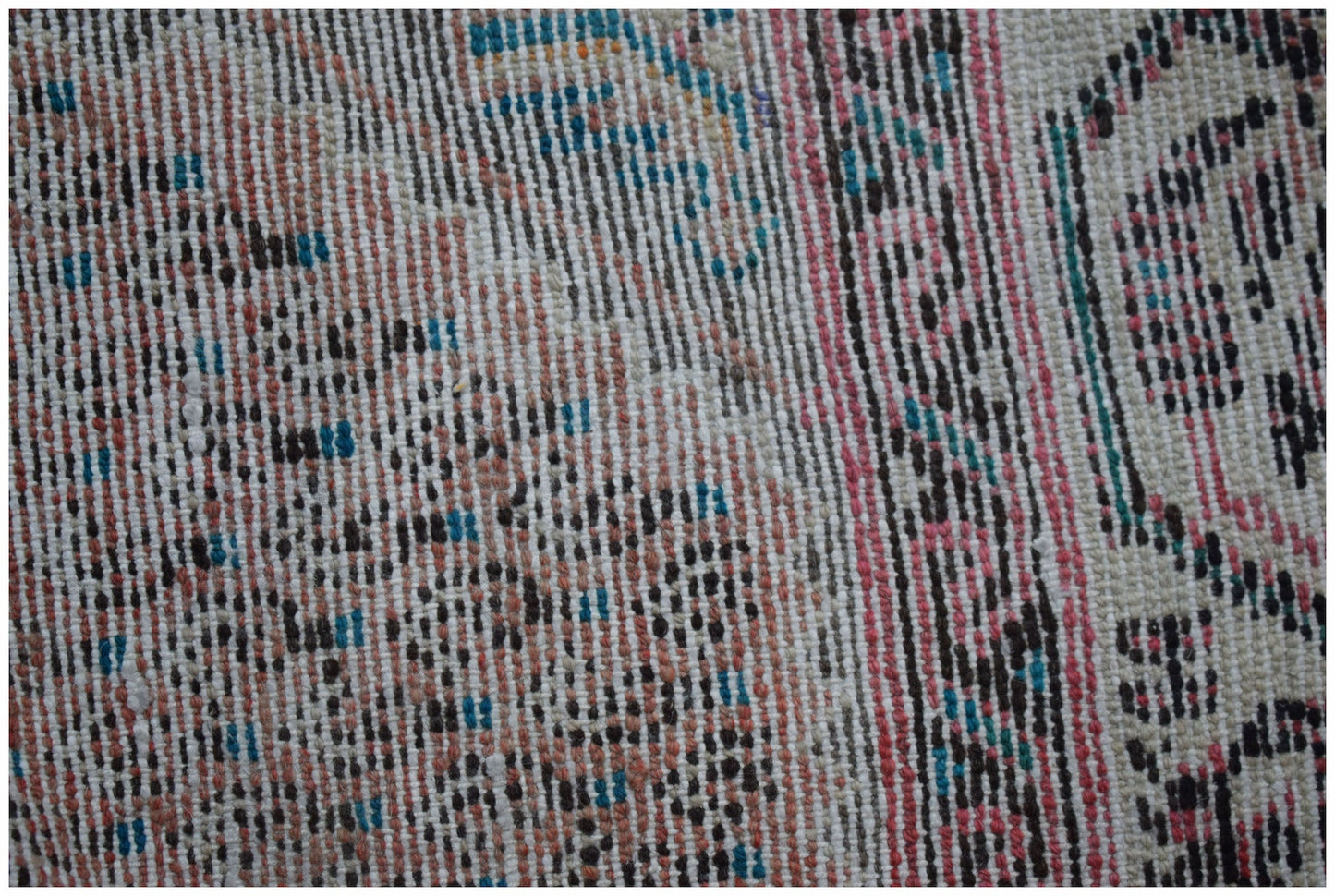 A close-up view of a handwoven vintage Persian rug featuring a textured pattern of wool fibers.