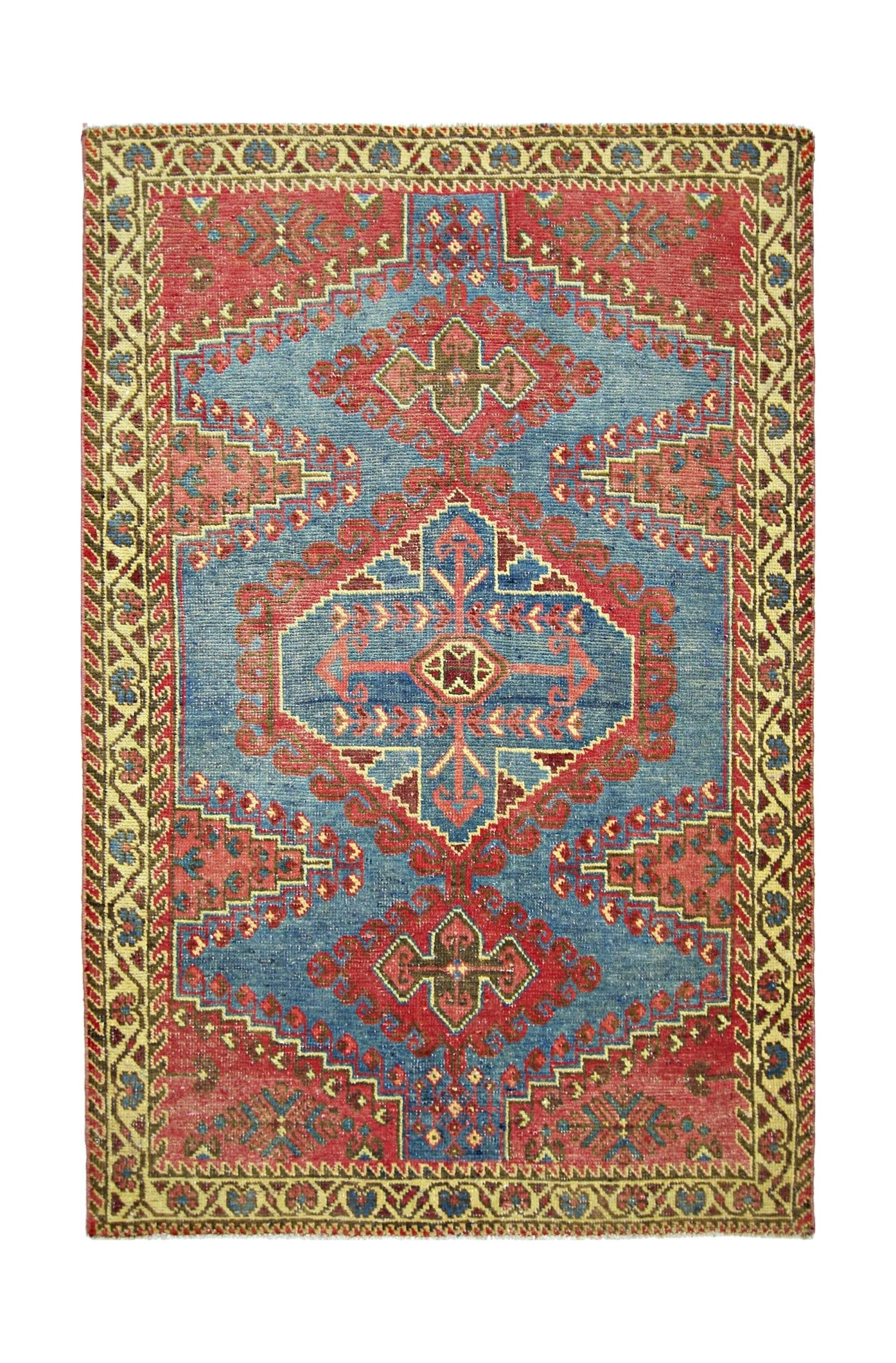 A vintage handmade Persian Wiss rug featuring a geometric medallion pattern in red and blue.