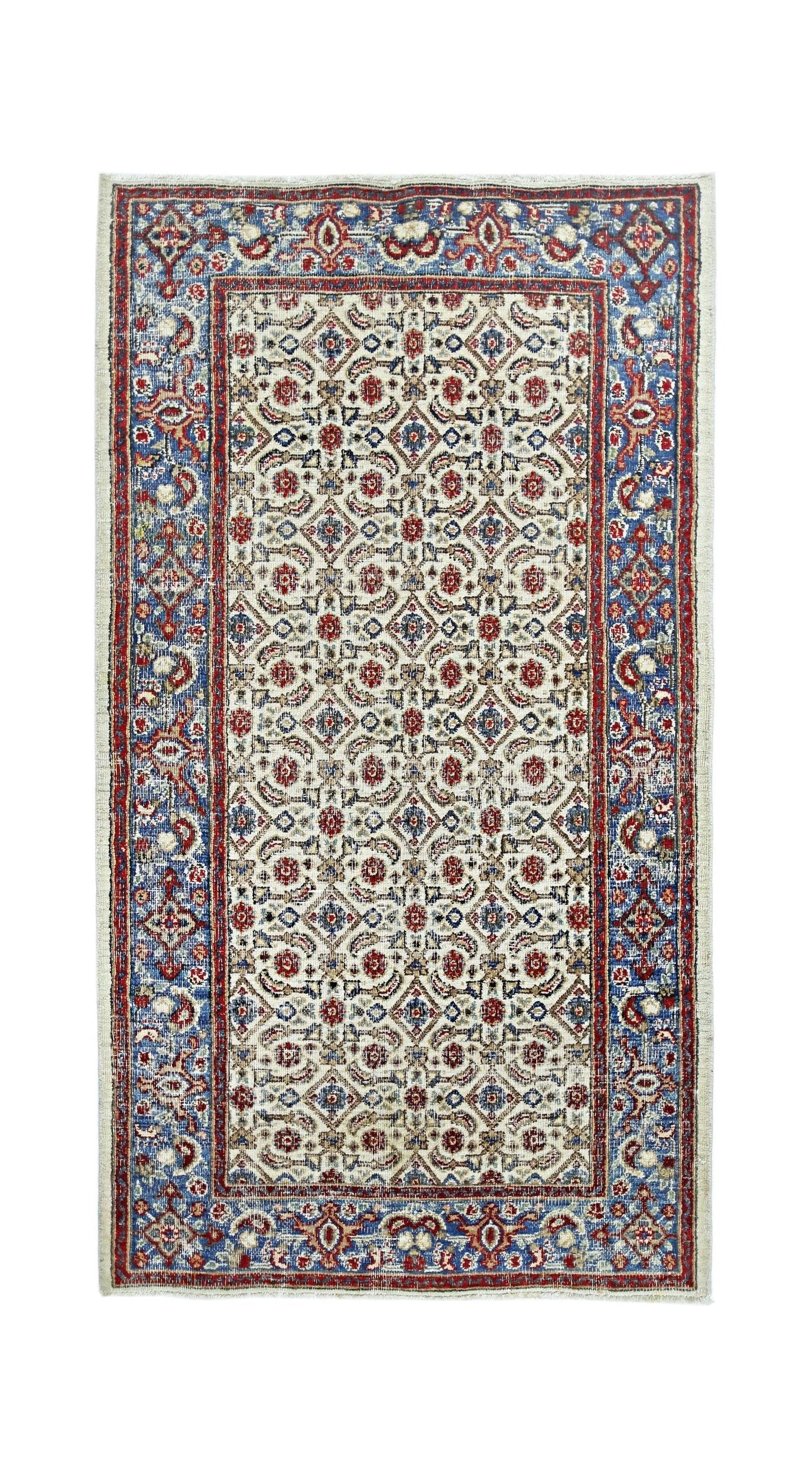 A vintage Persian Saraband rug featuring a repeating geometric pattern in red and blue on a cream base.