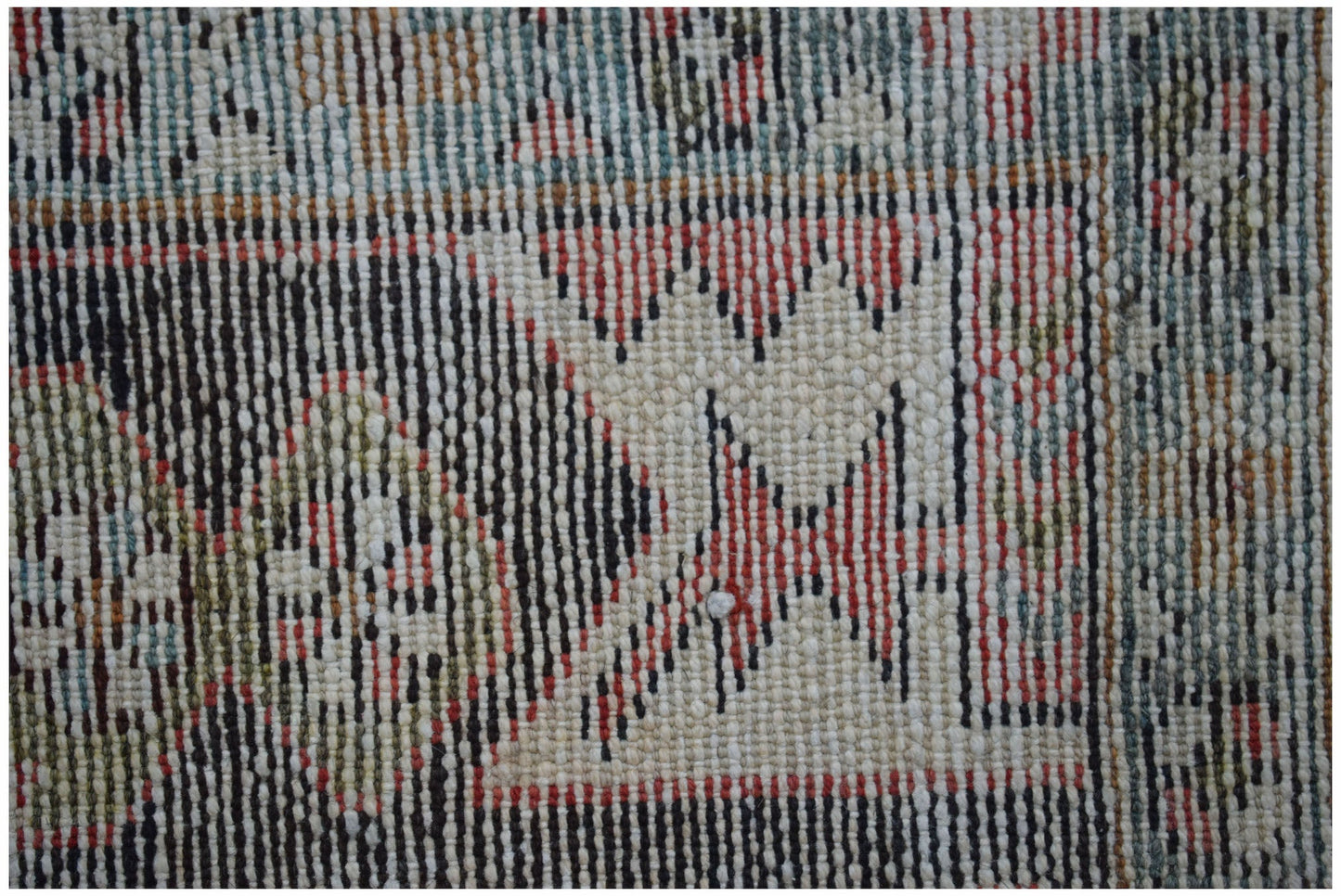 A close-up of a vintage Persian Hamadan rug featuring geometric patterns in red, black, and cream.