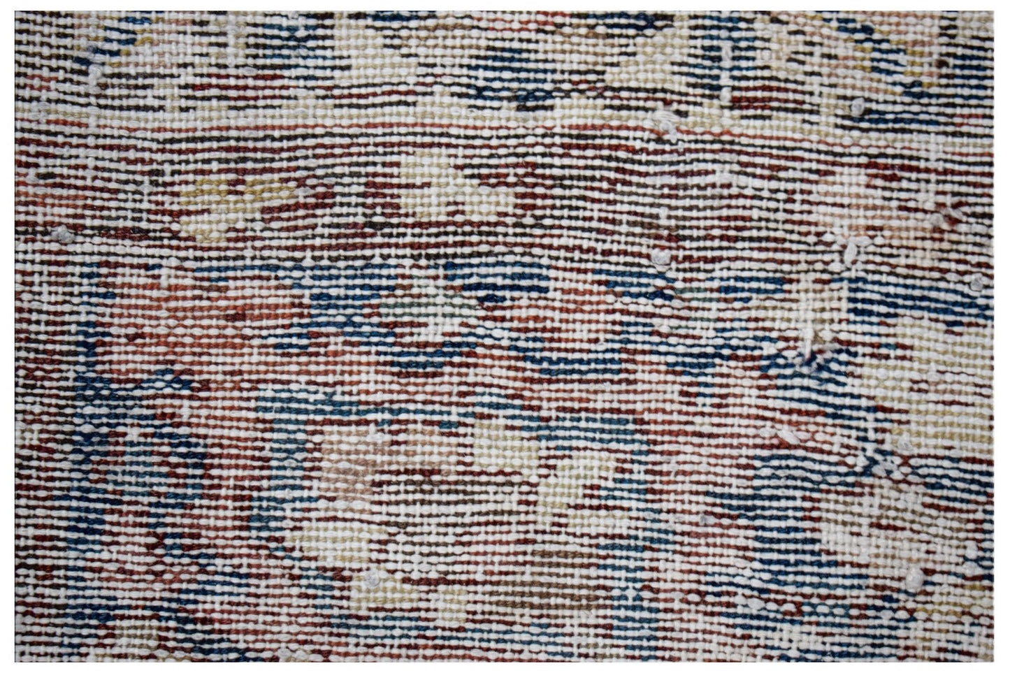A close-up view of a handwoven vintage Persian rug featuring a worn, multicolored wool pattern.