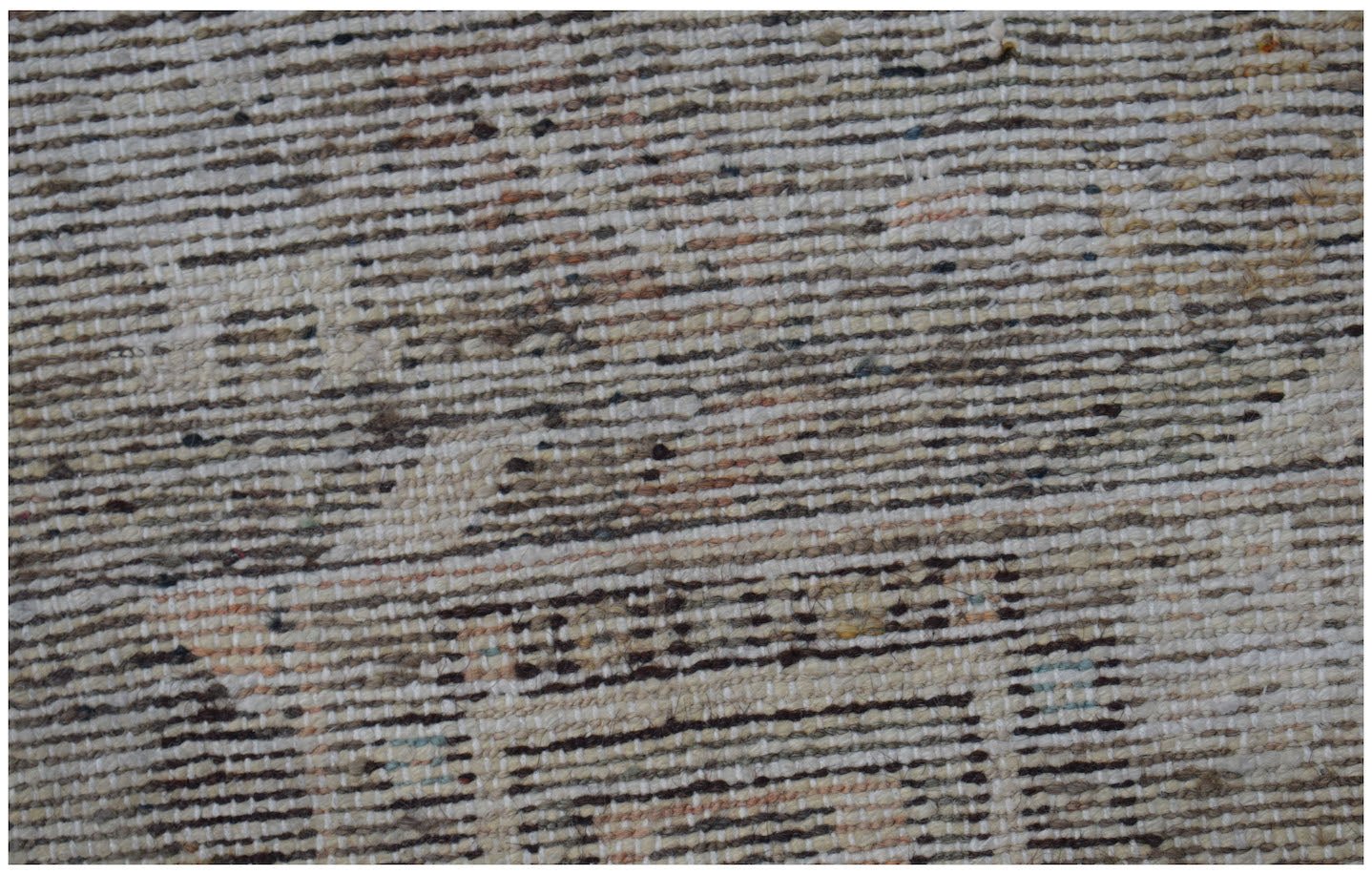 A close-up view of a handwoven vintage Persian rug featuring a textured, distressed wool pattern.