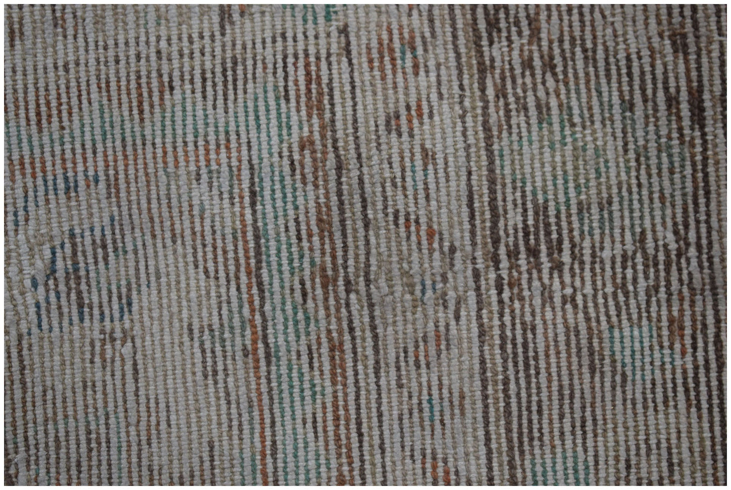 A close-up of a vintage Persian Sarouk rug featuring a faded, handwoven pattern in wool.