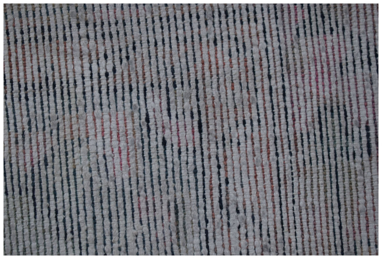A close-up of a vintage Persian rug featuring a textured, handwoven pattern of vertical stripes.
