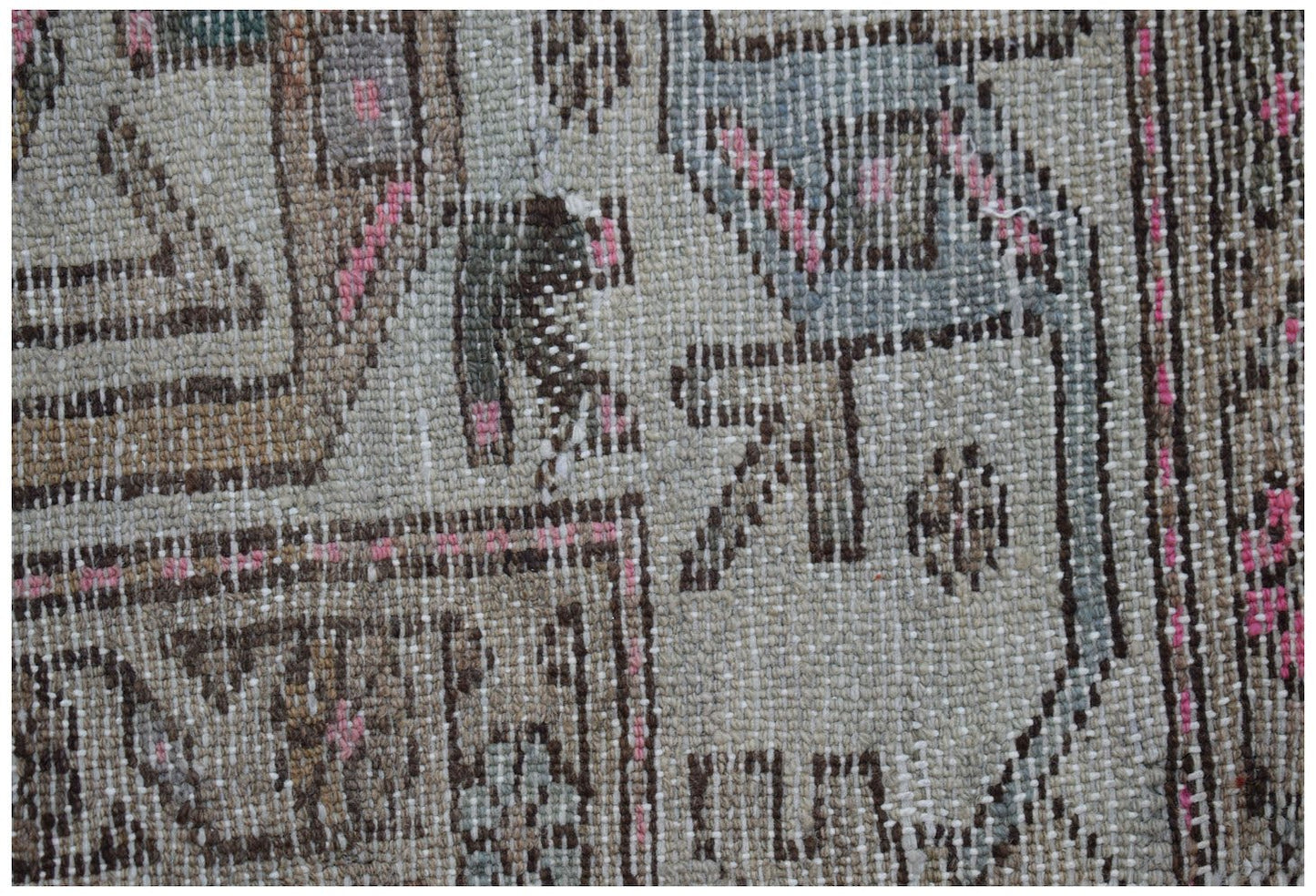 A close-up of a handwoven vintage Persian rug featuring intricate geometric patterns in wool.