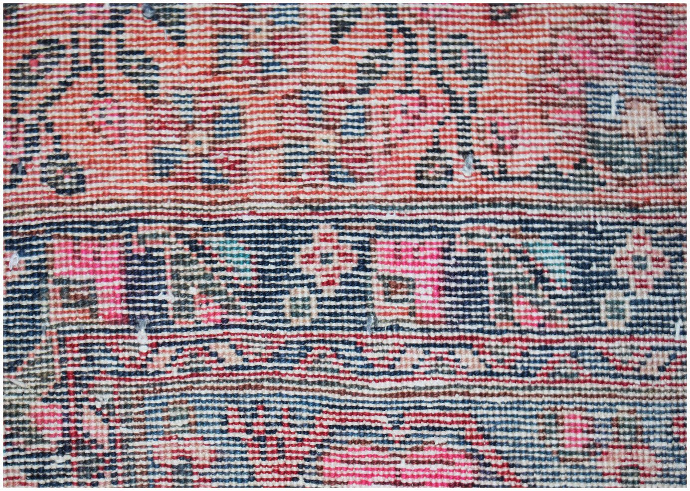 A close-up of a vintage Persian rug featuring intricate floral patterns in red, blue, and cream.