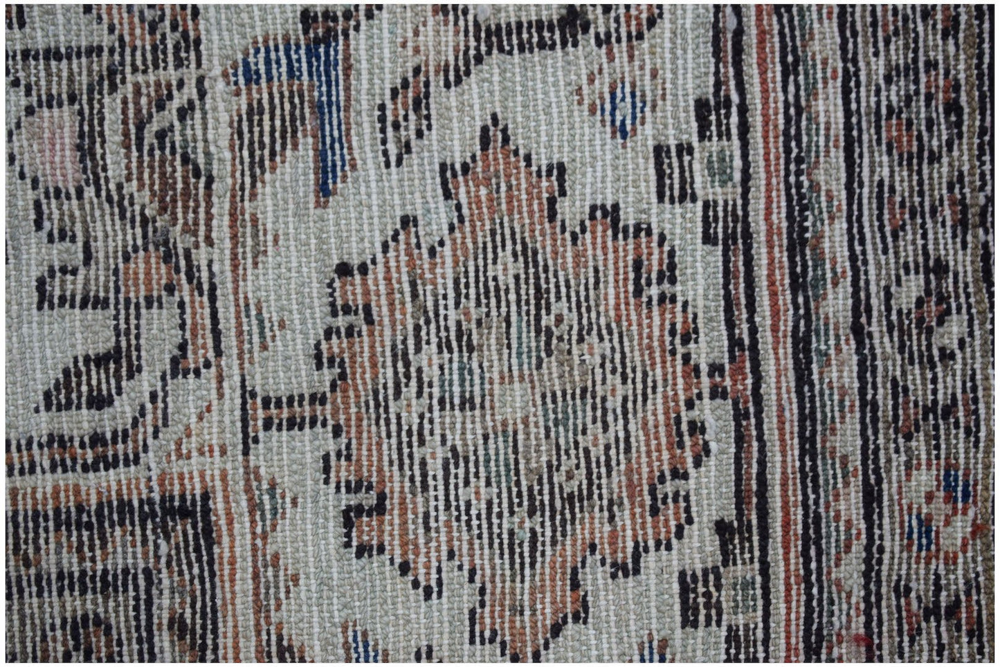 A close-up of a vintage handwoven Persian rug featuring intricate floral patterns in muted tones.