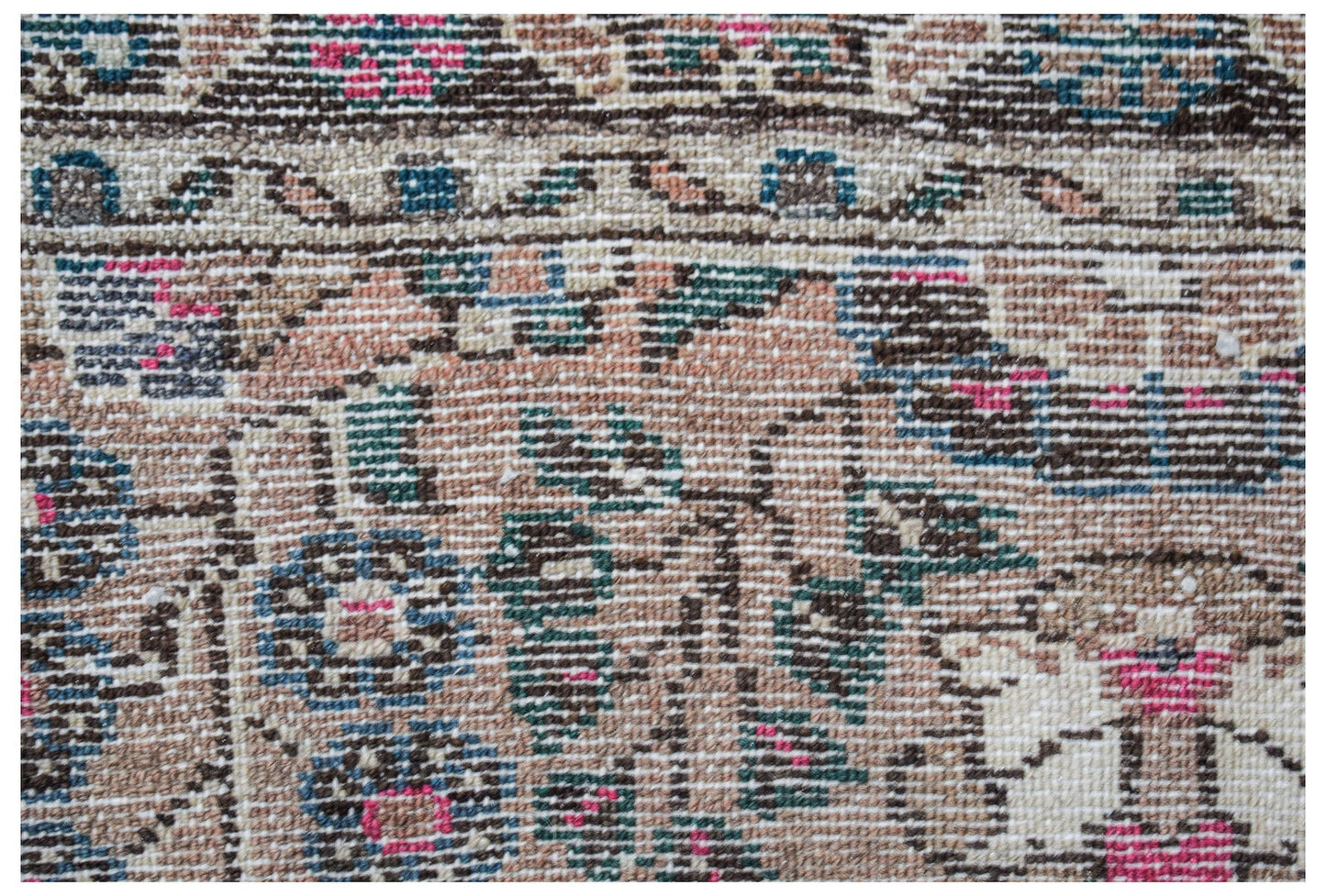 A close-up view of a vintage Persian Sarouk rug featuring intricate floral patterns in wool.