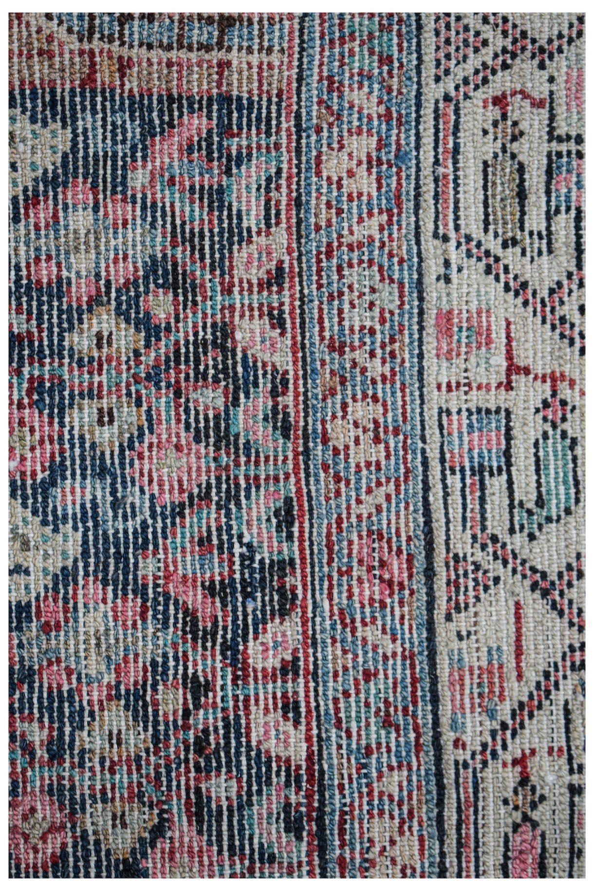A close-up of a vintage Persian Senneh runner featuring intricate floral patterns in wool.