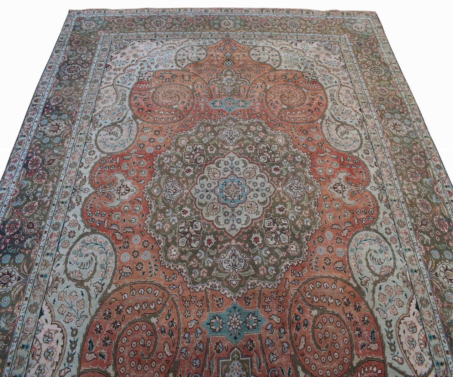 A vintage handwoven Persian Tabriz rug featuring intricate floral patterns in orange and green.