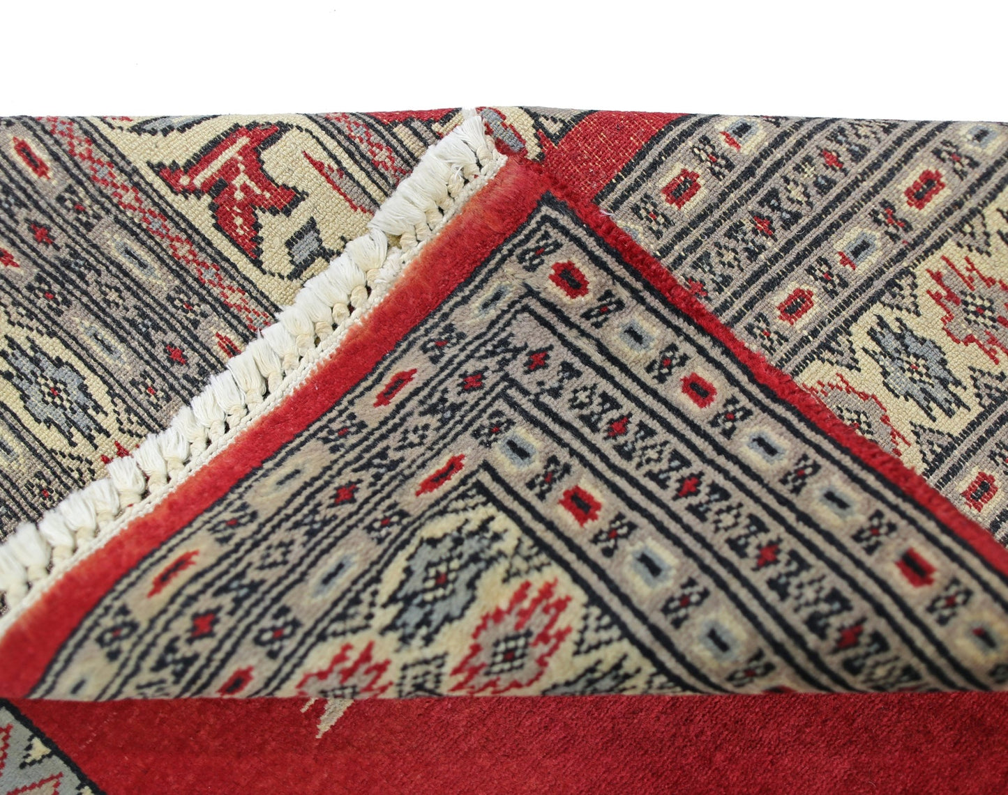 A vintage Pakistani Bokhara rug with a red field and intricate geometric patterns.