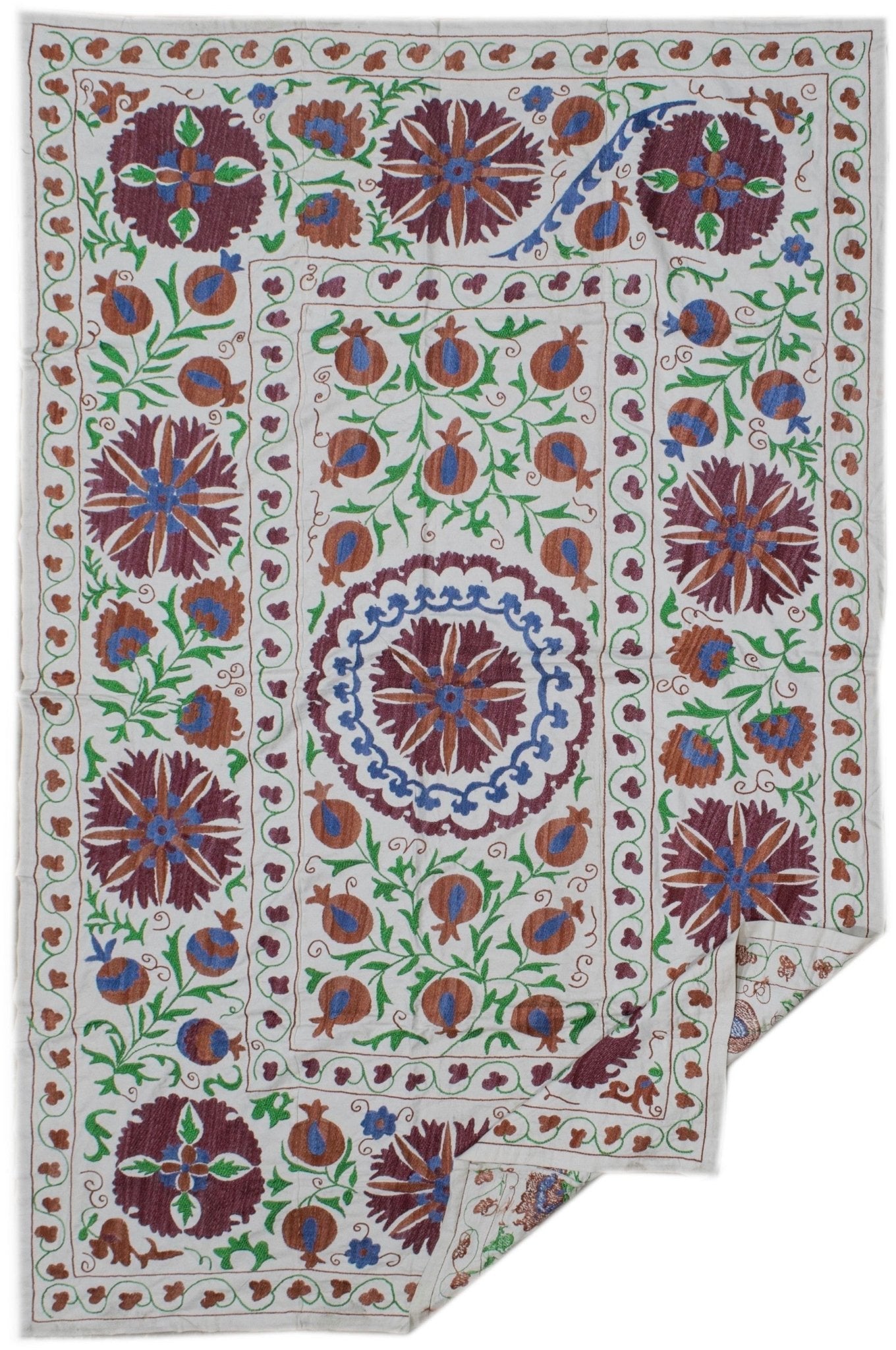 Handmade Uzbek suzani featuring intricate floral and pomegranate embroidery on a cotton base.