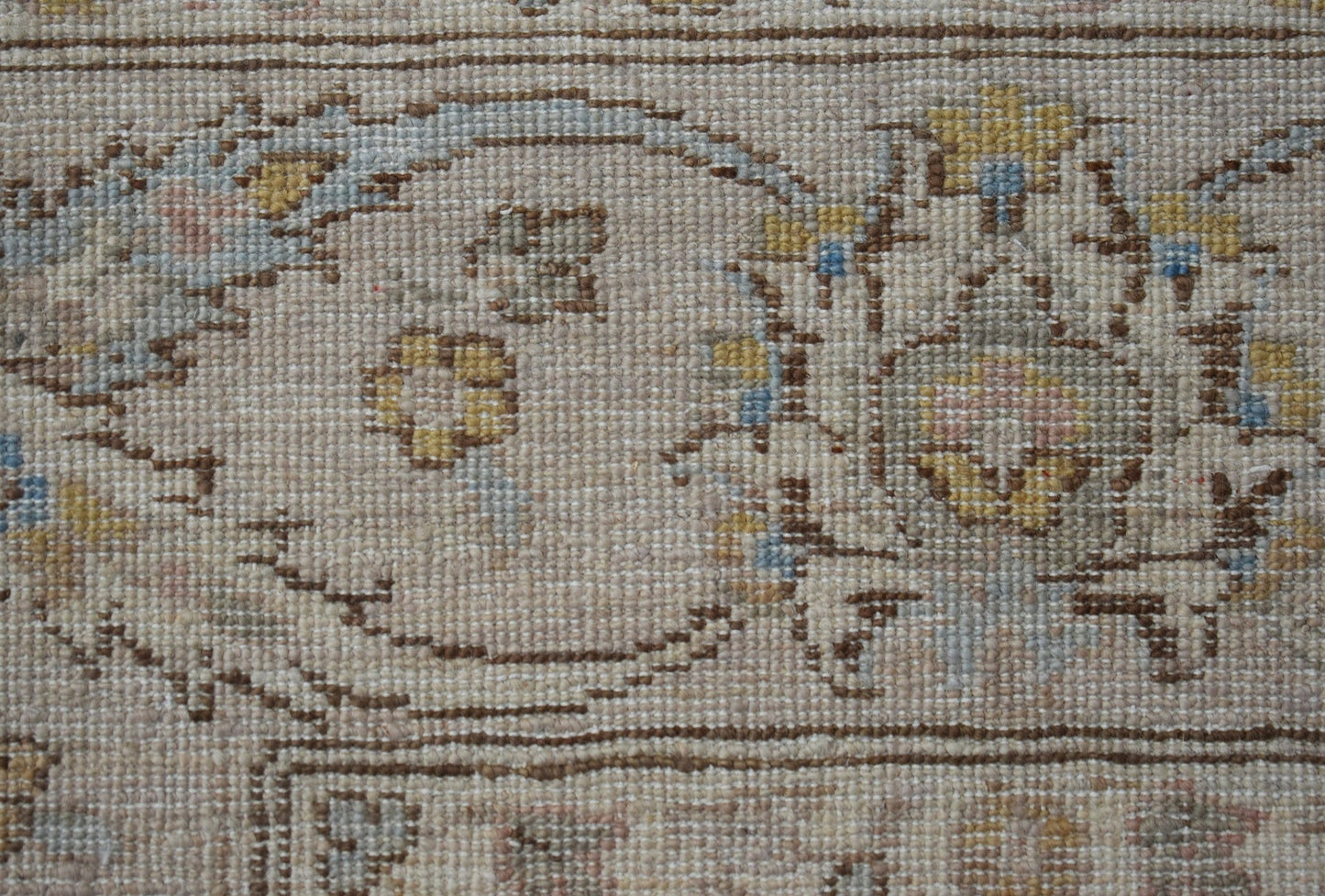 A close-up of an Afghan Chobi rug featuring intricate floral patterns in soft, earthy tones.
