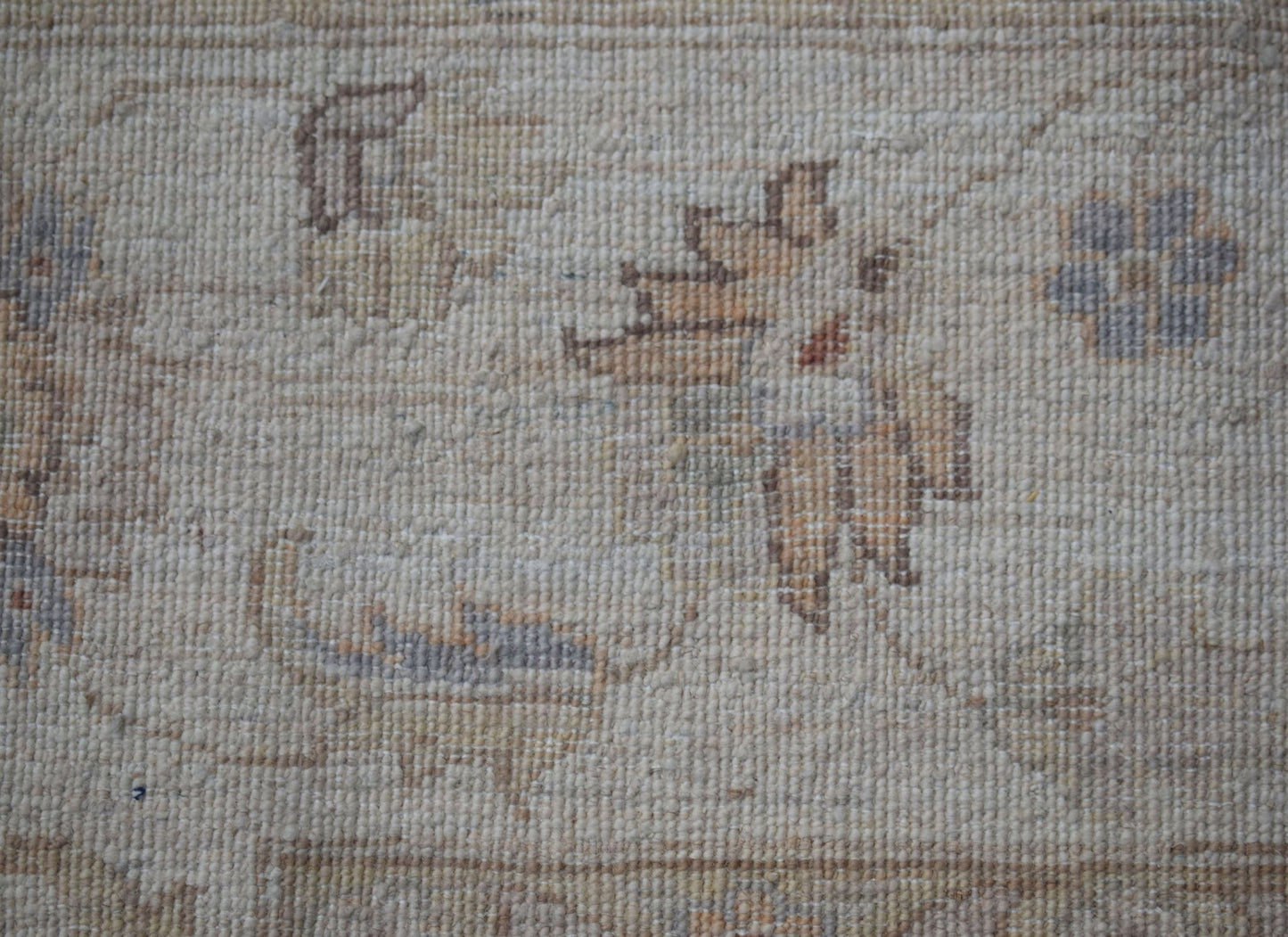 A close-up of a handwoven Afghan Chobi rug featuring traditional floral motifs in earthy tones.