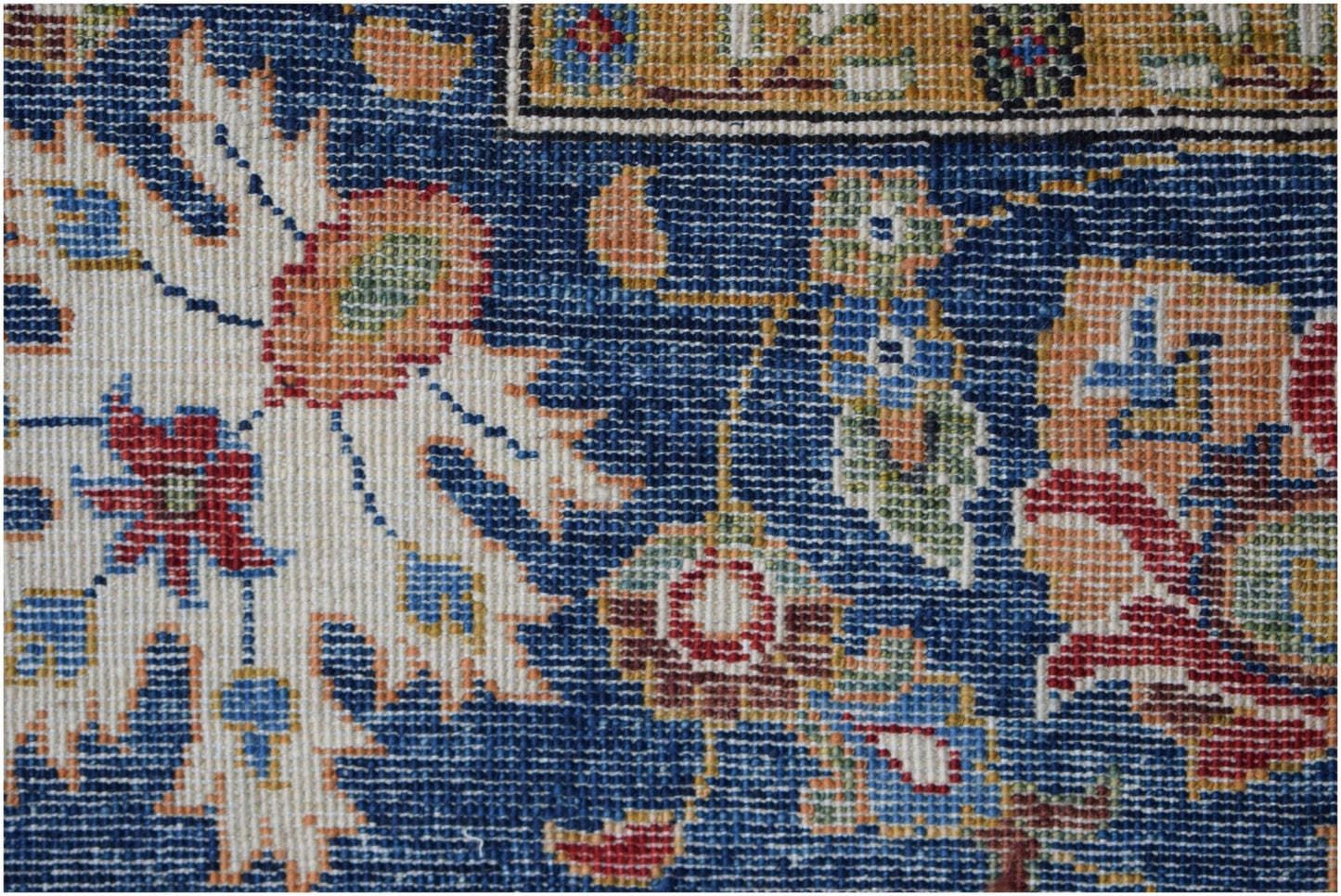 A close-up of a handwoven Afghan Chobi rug featuring intricate floral patterns in a blue field.