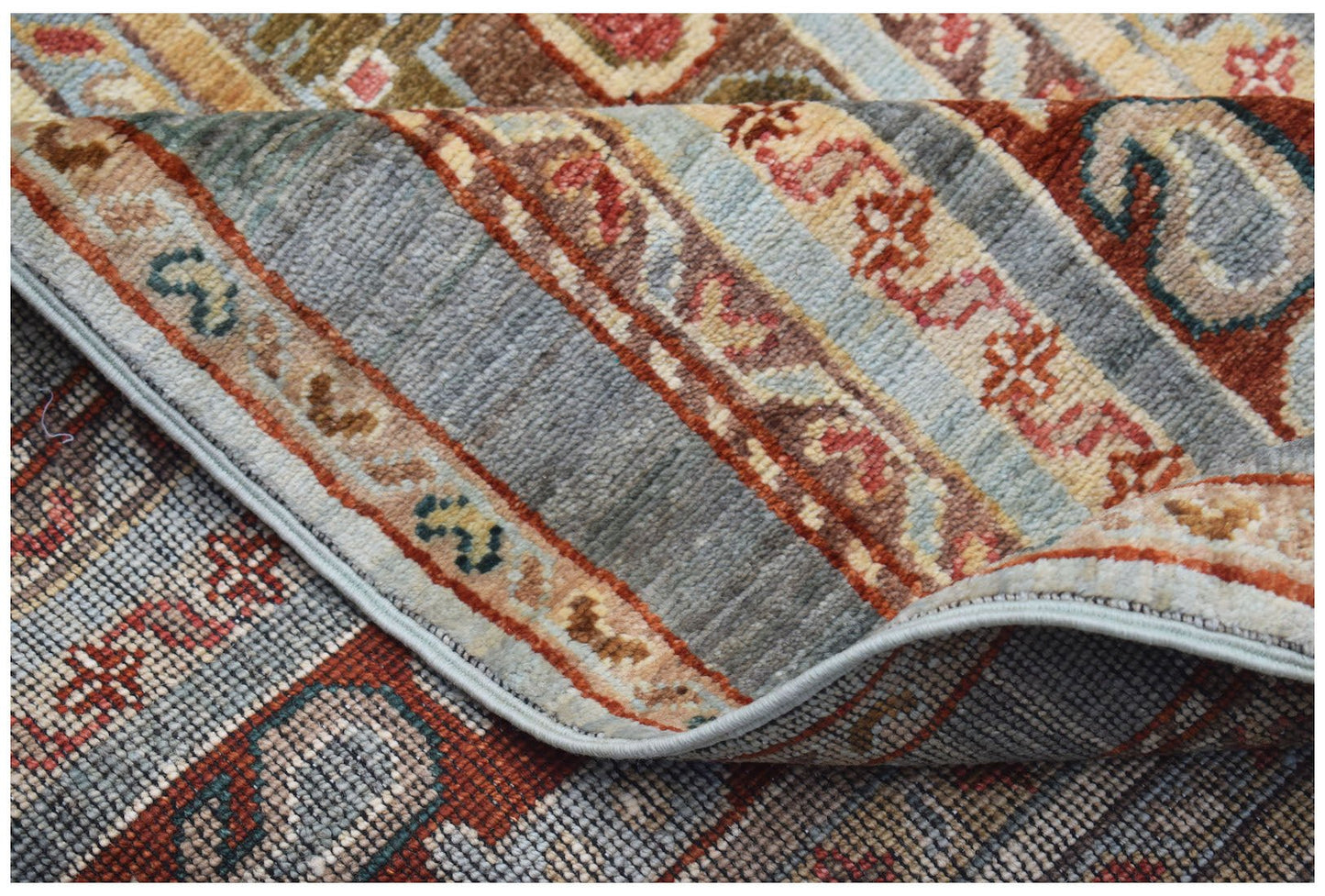 A handwoven Afghan Chobi runner featuring traditional patterns in earthy tones on a wool pile.
