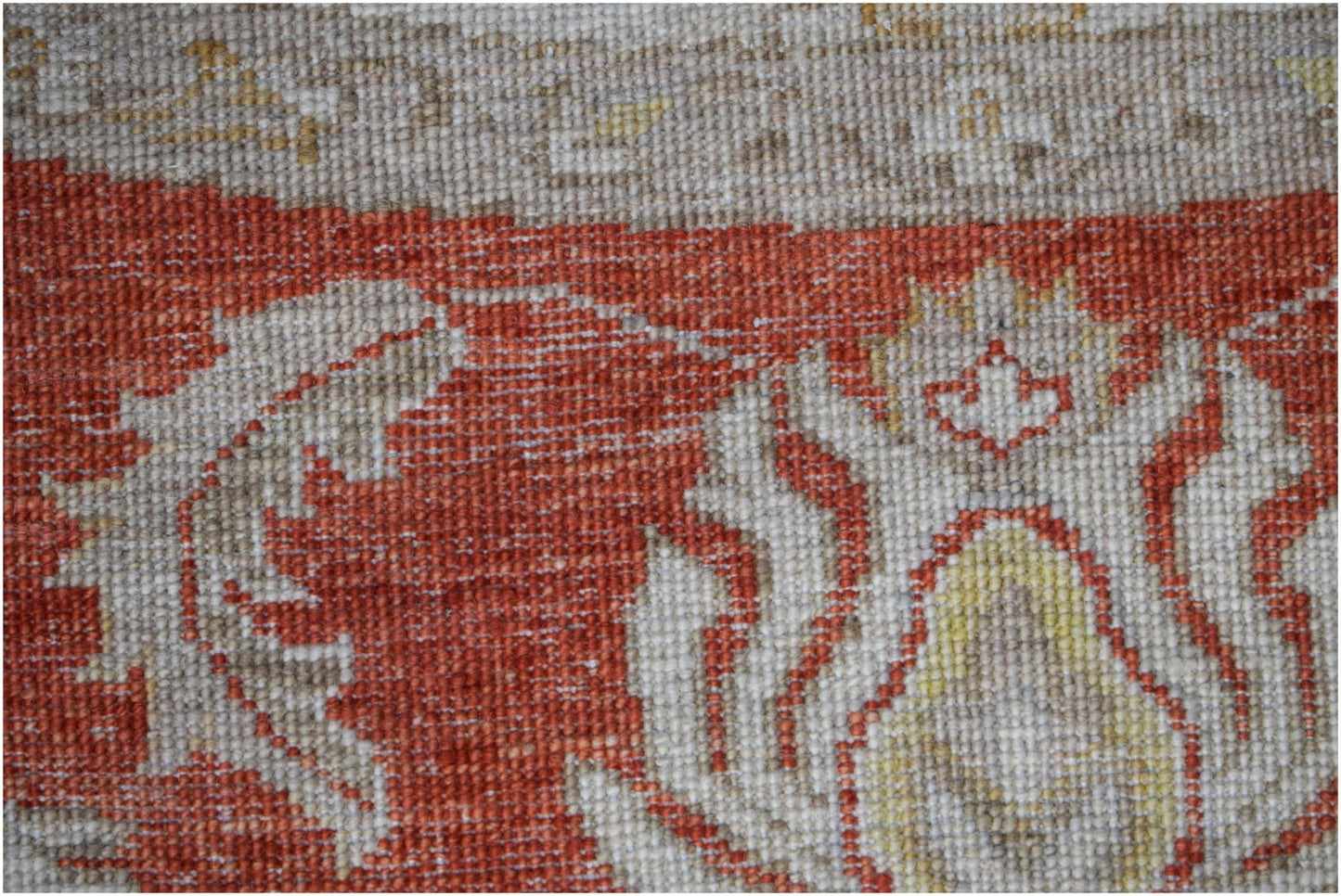A close-up of a handwoven Afghan Chobi rug featuring intricate floral patterns in rust and cream.