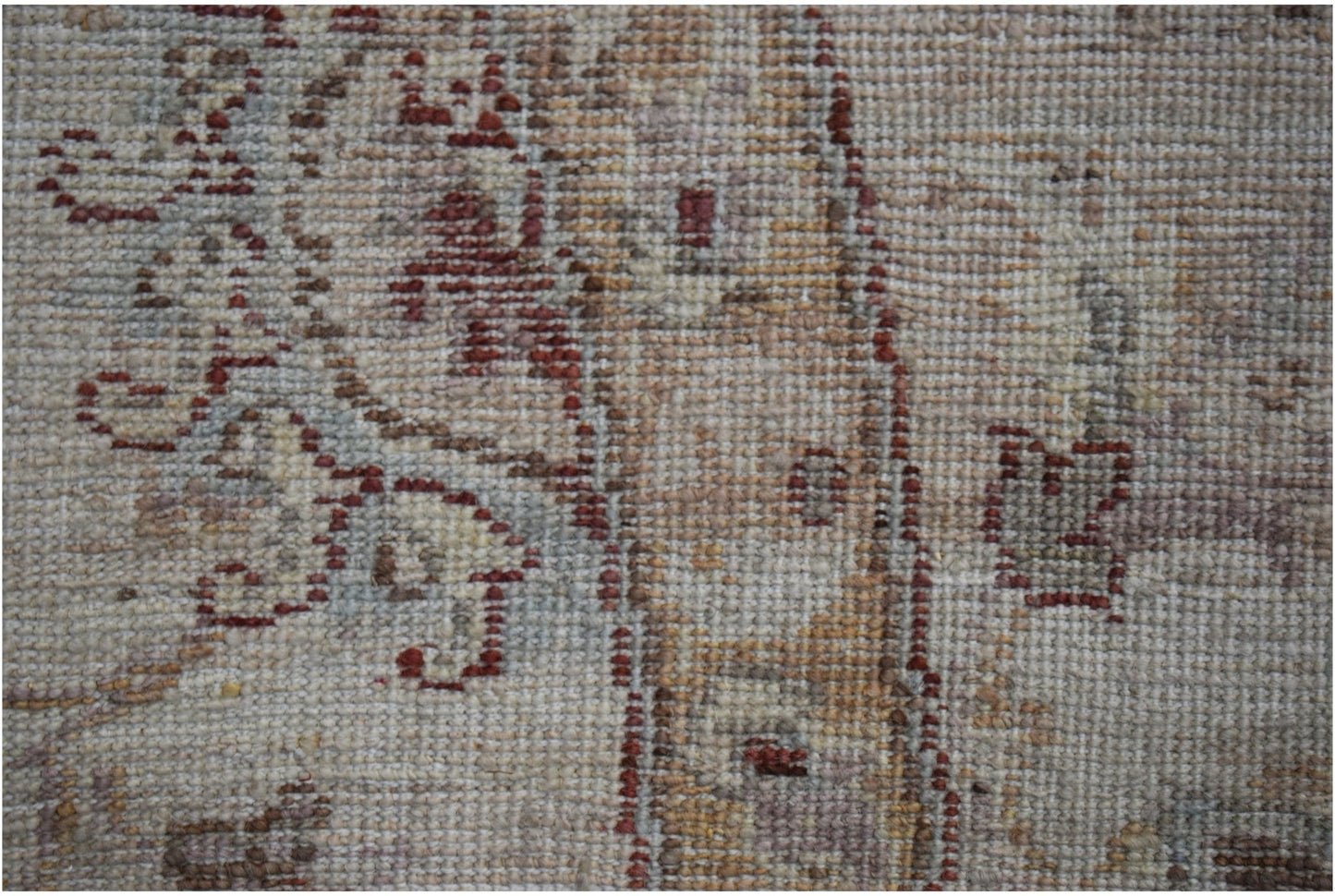 A close-up of a handwoven Afghan Chobi rug featuring traditional patterns in earthy wood tones.