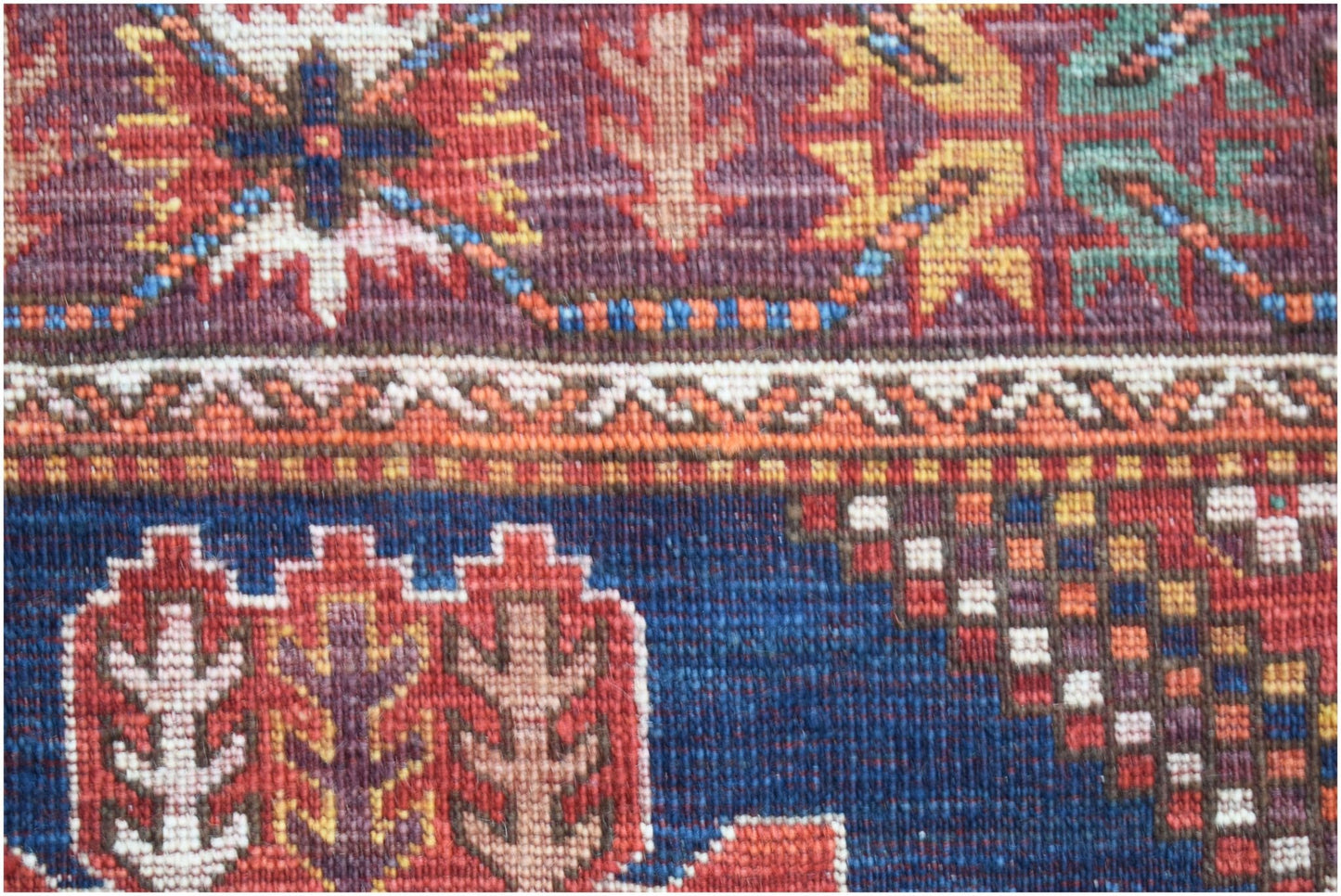 A close-up of an Afghan Herati runner featuring intricate geometric patterns in wool.