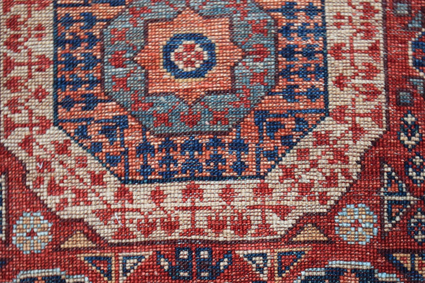 A close-up of a handwoven Afghan Chobi runner featuring a detailed geometric Mamluk medallion.