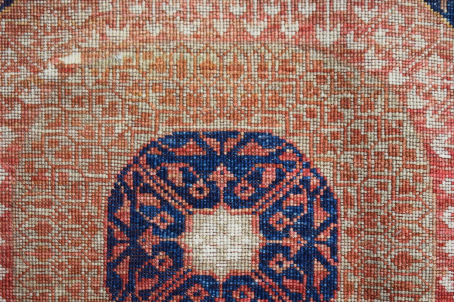 A close-up of a handwoven Afghan Chobi runner featuring a detailed blue and red Mamluk medallion.