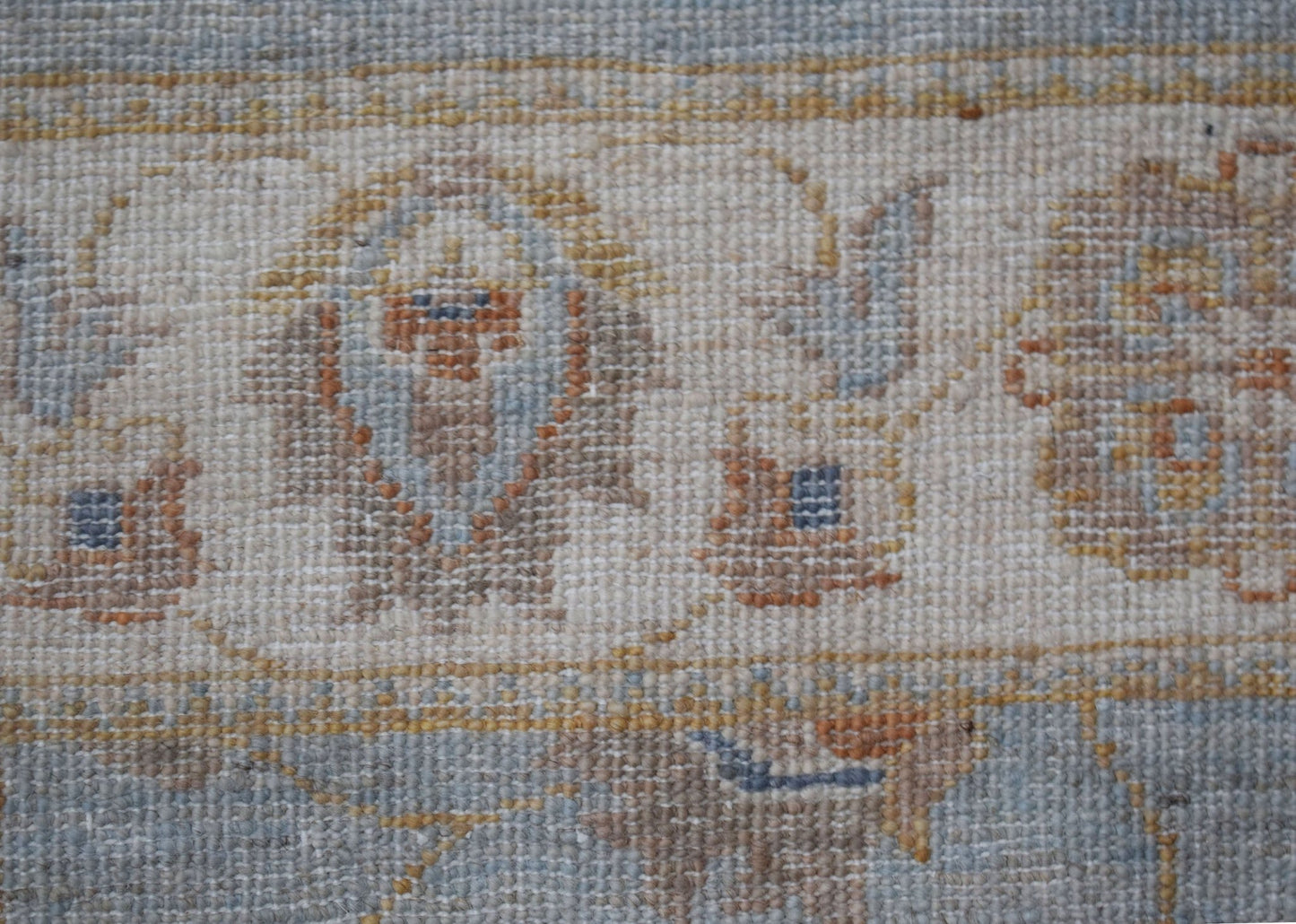 A close-up of a handwoven Afghan Chobi rug featuring traditional floral patterns in earthy tones.