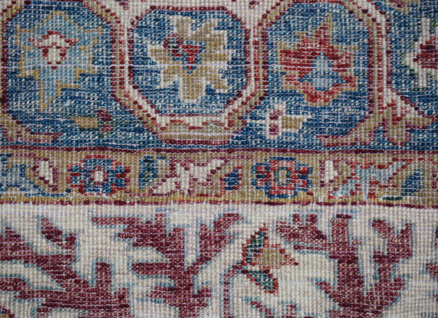 A close-up of a handwoven Afghan Chobi rug featuring intricate floral patterns in red and blue.
