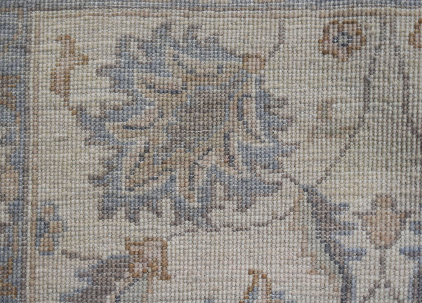 A close-up of a handwoven Afghan Chobi runner featuring intricate floral patterns in muted tones.