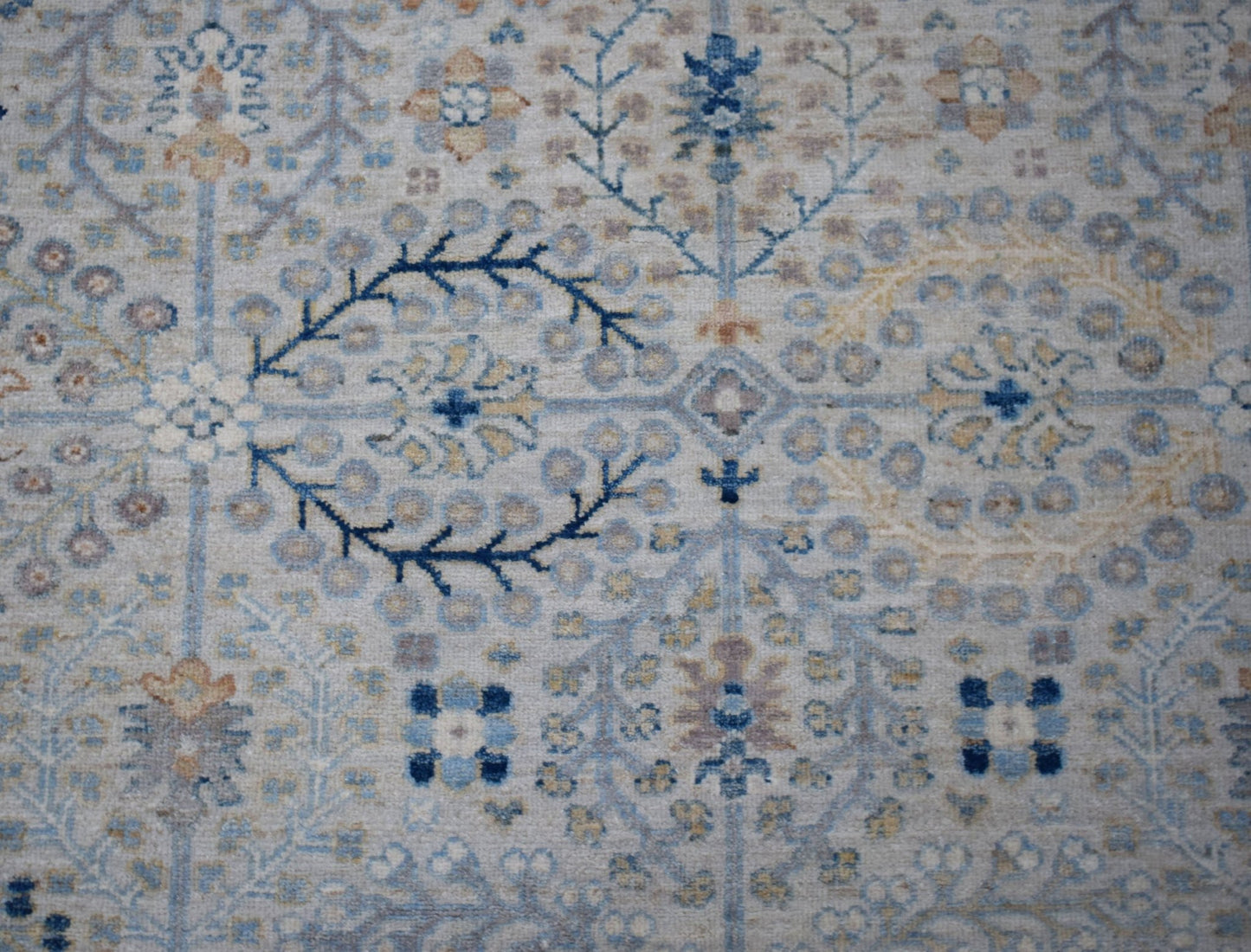 A handwoven Afghan Balkh rug featuring a traditional floral pattern in soft blue and beige tones.