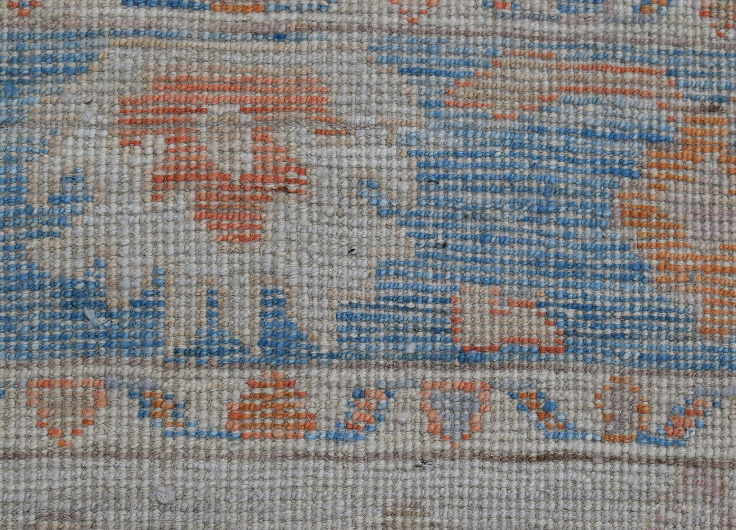 A handwoven wool runner featuring a transitional Oushak pattern in blue and orange tones.
