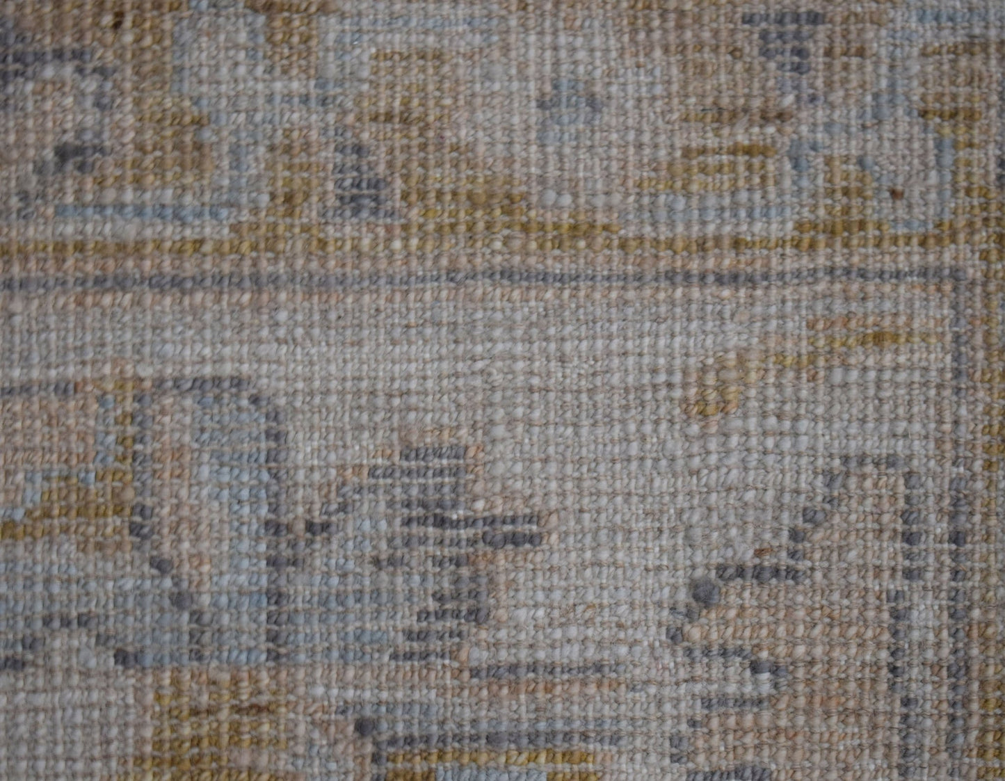 A close-up view of a handwoven transitional Oushak rug featuring a textured wool pile.