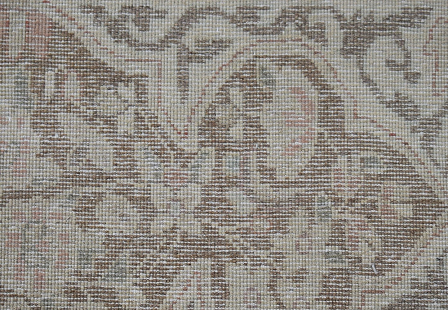 A close-up view of a vintage Persian Kerman rug featuring intricate floral patterns in muted tones.