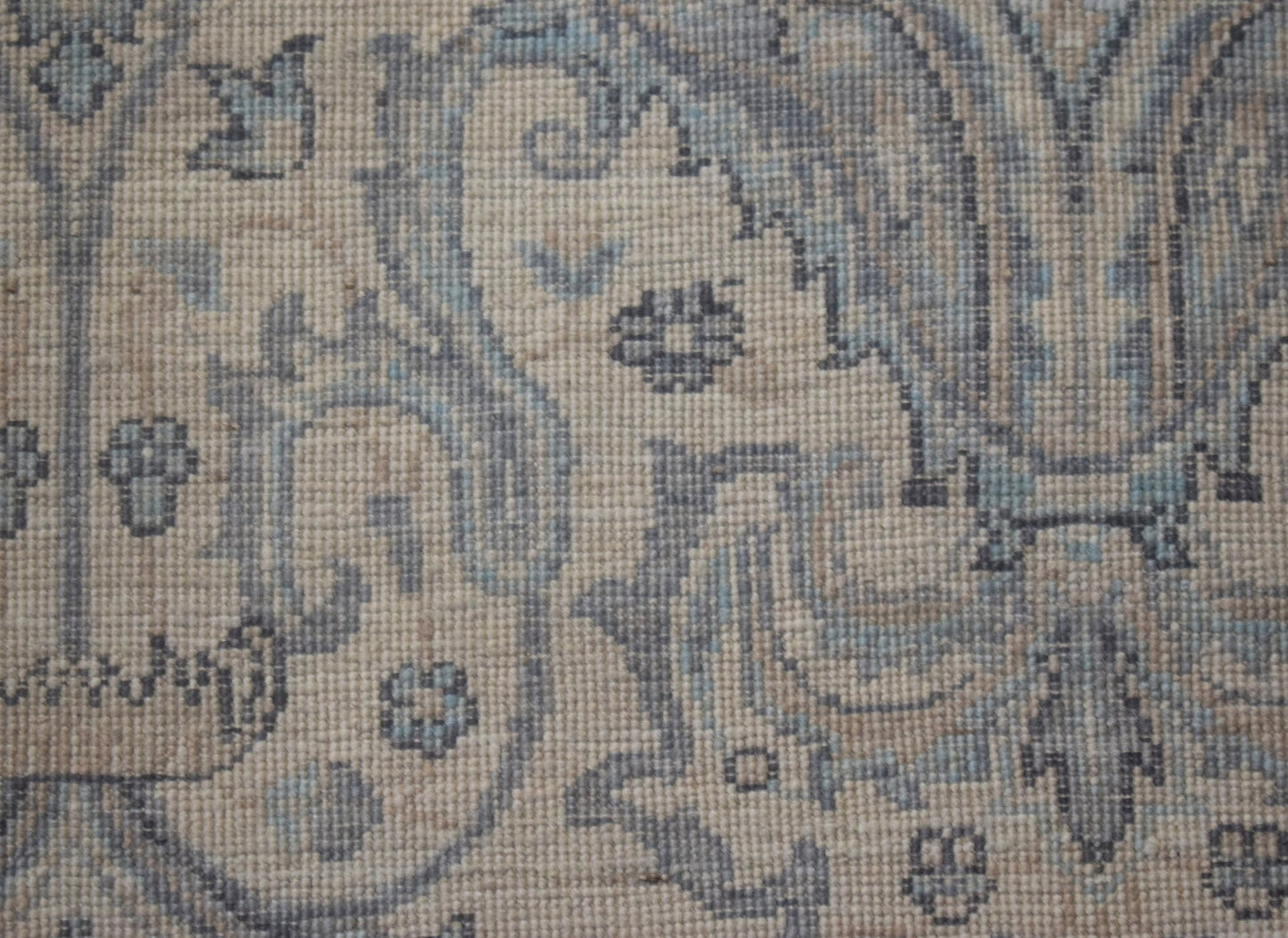 A handwoven Afghan Balkh rug featuring intricate blue and beige floral patterns on wool.