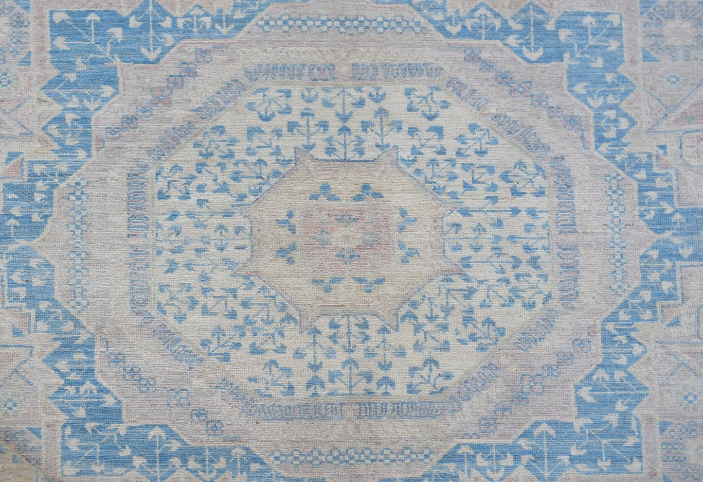 Handwoven Afghan Balkh rug featuring a traditional geometric pattern in soft blue and cream tones.