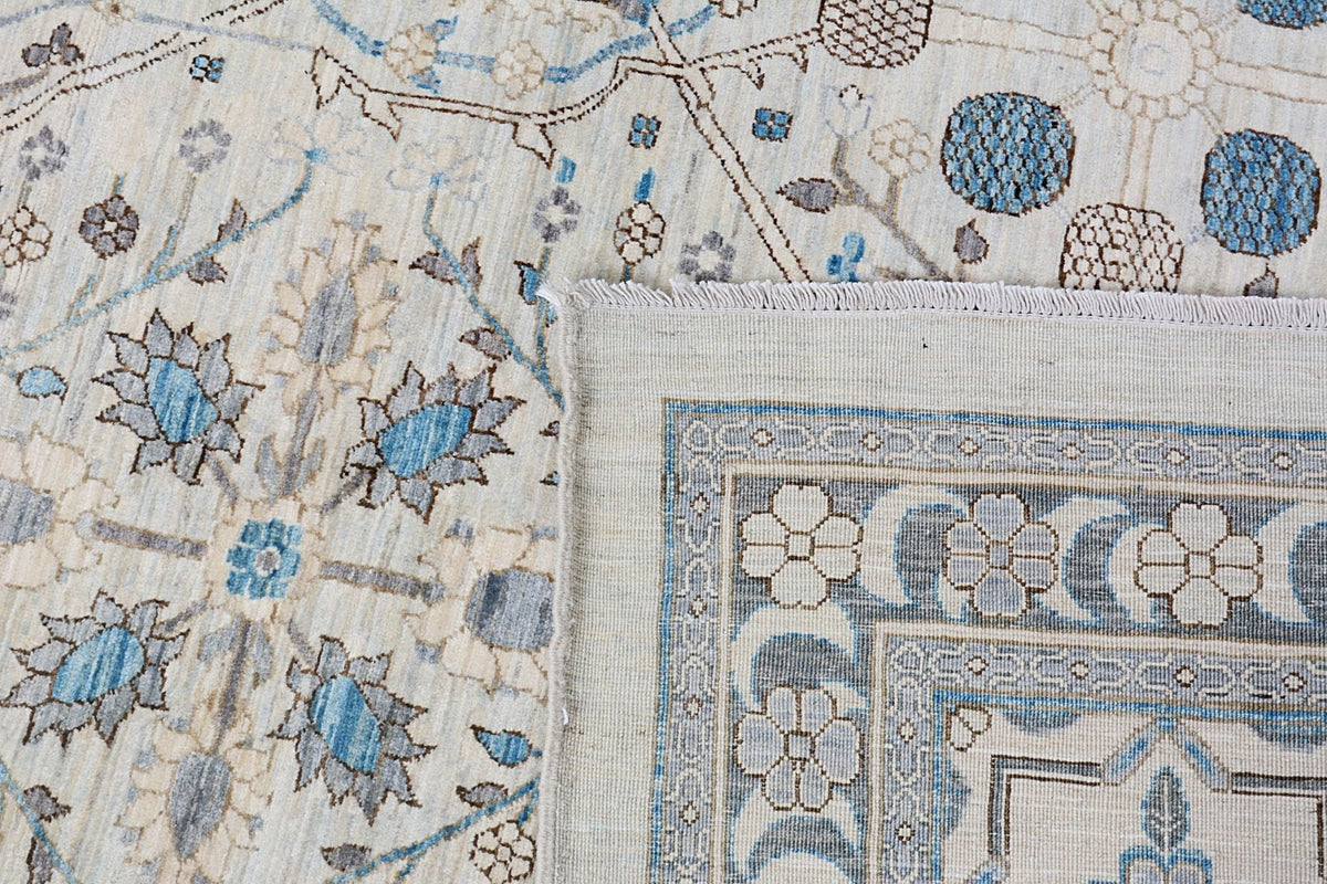 A handmade Afghan Balkh rug featuring a traditional floral pattern in blue, grey, and cream tones.