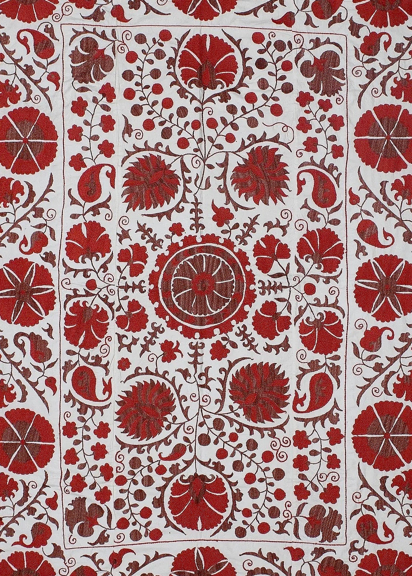 A white cotton textile featuring intricate red floral and paisley embroidery in a traditional style.