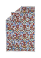 Hand-embroidered Uzbek suzani featuring a repeating floral pattern in red, blue, and gold on cotton.