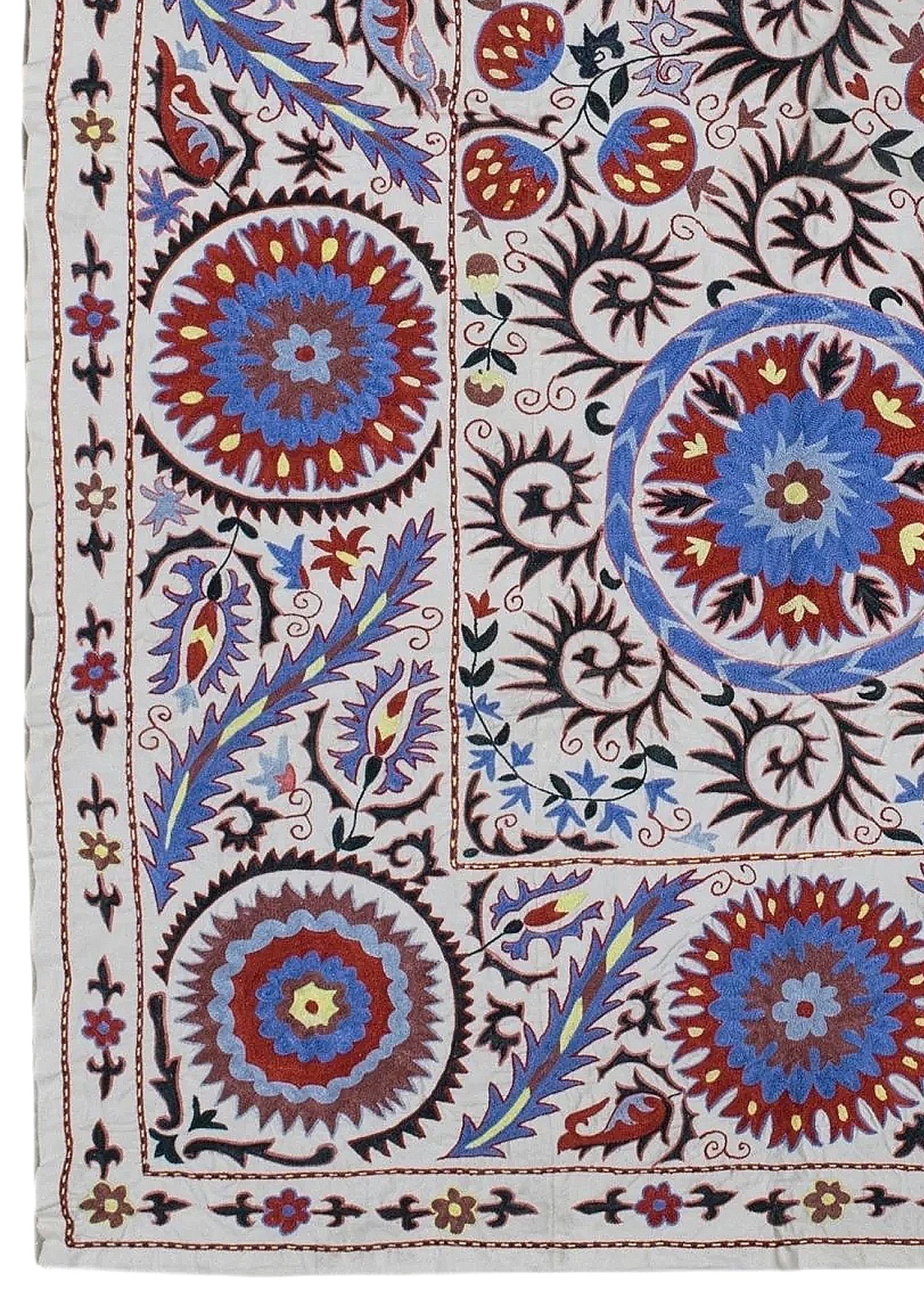 Hand-embroidered Uzbek Suzani textile featuring vibrant floral and circular motifs on cotton.