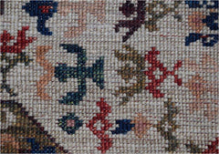 A close-up of a handmade Afghan Chobi runner featuring intricate geometric and floral motifs.