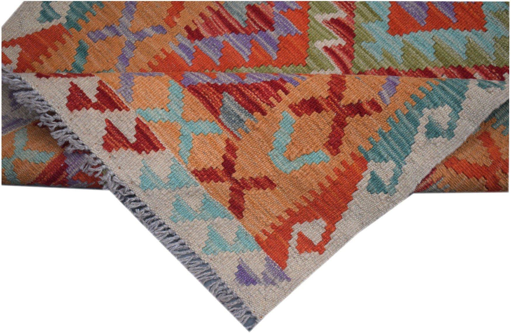A handmade Afghan Maimana kilim runner featuring vibrant geometric patterns in wool.