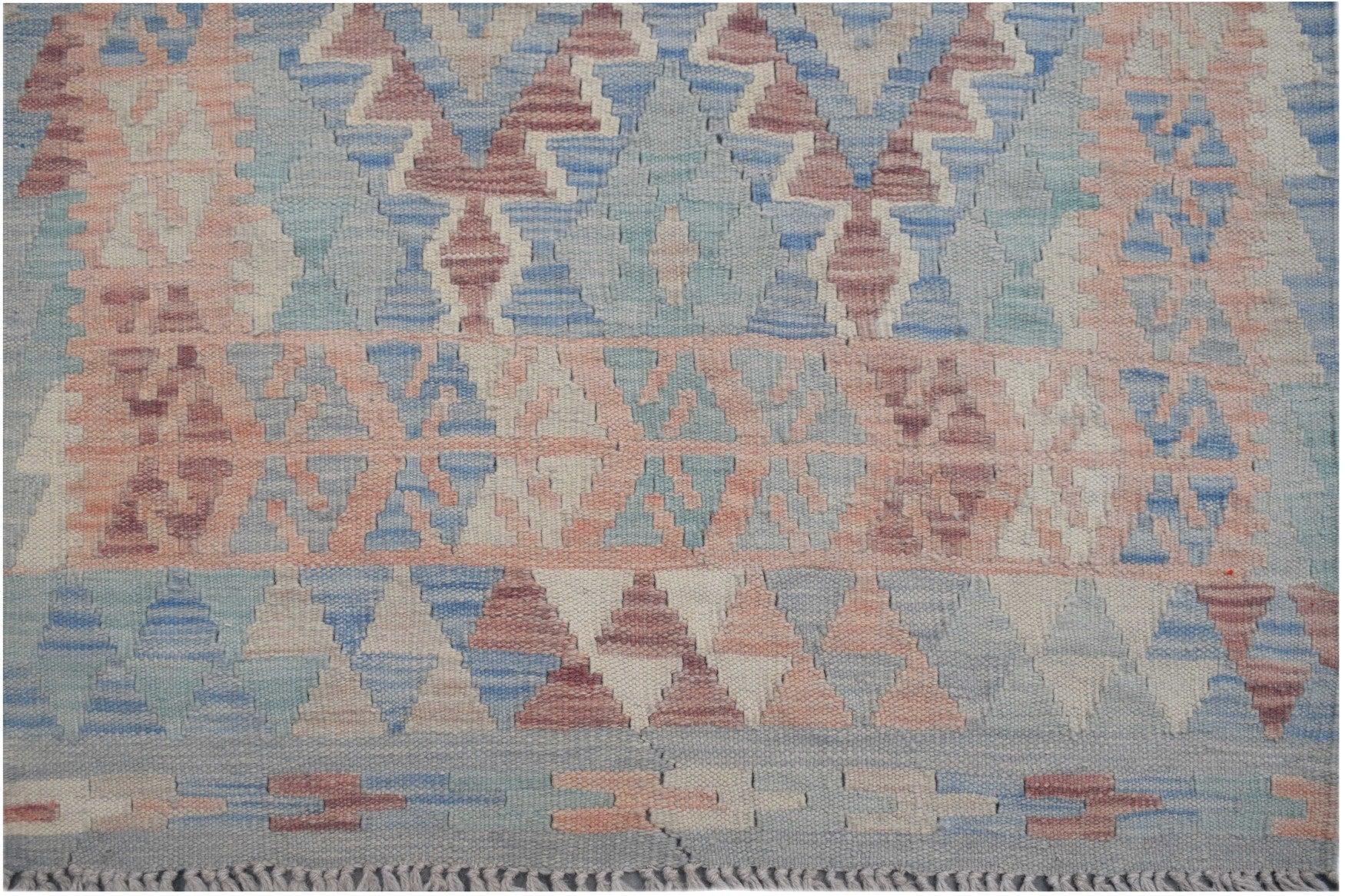 Handmade Afghan Maimana kilim runner featuring a geometric pattern in blue, pink, and cream wool.