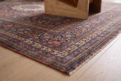 Vintage Persian Moud rug with intricate floral patterns in navy, red, and gold, featuring a hand-knotted wool pile and fringe.