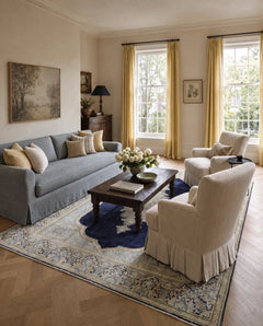 Vintage Persian Kerman rug with a central navy medallion and intricate floral borders in a light-filled living room.