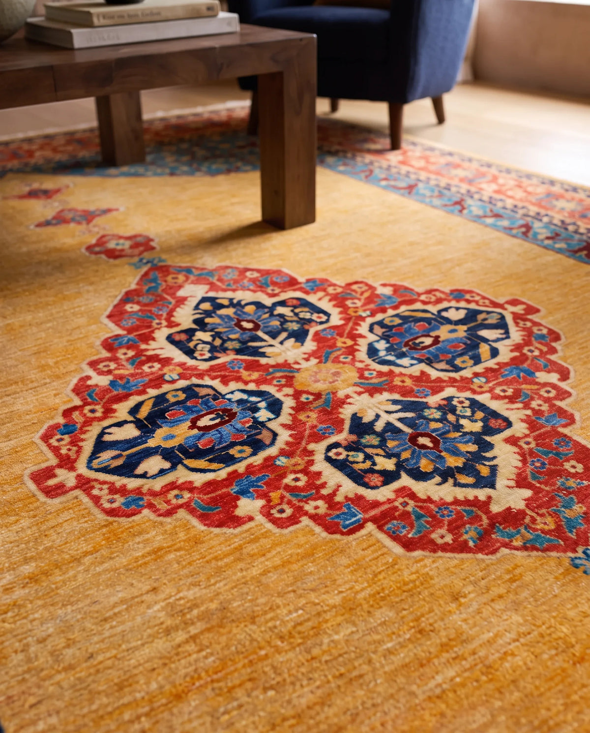 Hand-knotted Afghan Balkh rug with a golden-yellow field and intricate red and blue floral medallion patterns.