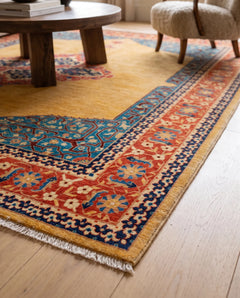 Hand-knotted Afghan Balkh rug with a golden yellow field, intricate blue and red floral borders, and a fine wool fringe.