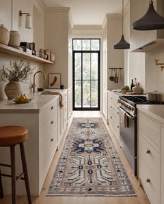 Vintage Caucasian Kazak runner with geometric blue and cream medallions on a light pink field, styled in a modern kitchen.
