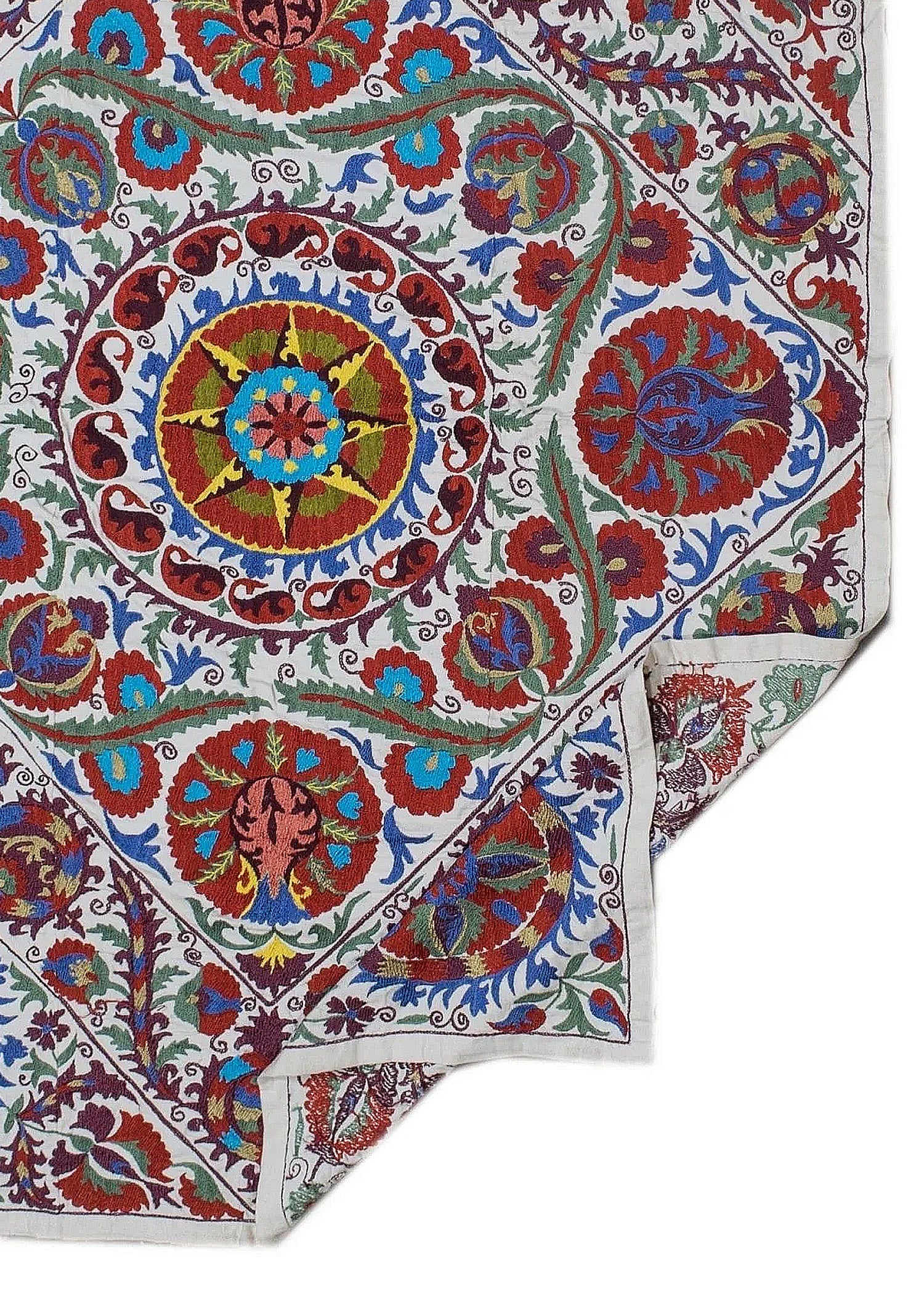 Hand-embroidered Uzbek Suzani textile featuring vibrant floral and celestial motifs on cotton.