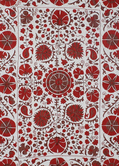 A white cotton textile featuring intricate red floral and paisley embroidery in a traditional style.